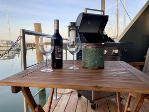 una mesa con dos copas de vino y una tostadora en Hausboot Moby Chic mit Dachterrasse in Kragenæs auf Lolland/DK en Torrig