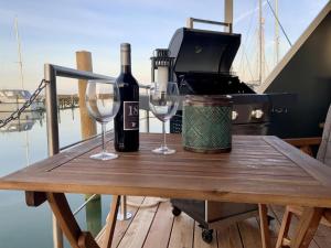 a table with two wine glasses and a toaster at Hausboot Moby Chic mit Dachterrasse in Kragenæs auf Lolland/DK in Torrig