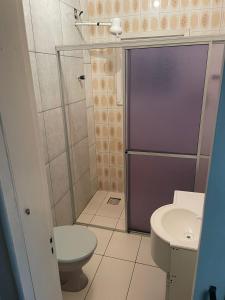 a small bathroom with a toilet and a shower at Residencial Brilha Mar in Capão da Canoa