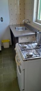 a kitchen with a sink and a stove top oven at Residencial Brilha Mar in Capão da Canoa