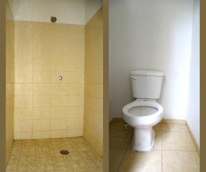a bathroom with a toilet and a tiled floor at Hostal Madrid in Tapachula