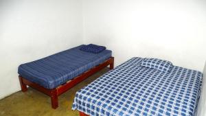 two beds in a room with blue sheets at Hostal Madrid in Tapachula