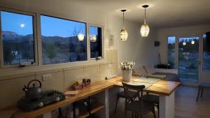 a dining room with a table and some windows at La Carmela Container house's in Esquel