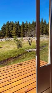 an open door to a deck with a view of a field at La Carmela Container house's in Esquel