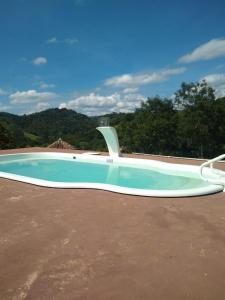 a large swimming pool sitting in a yard at Da Terra Brasil, Piscina e banheira dupla in Santo Antônio do Pinhal