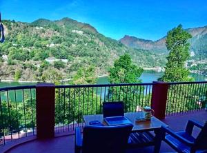 een balkon met uitzicht op een rivier en de bergen bij Sukoon Lake view BnB by Boho Stays in Nainital