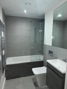 uma casa de banho com uma banheira, um WC e um lavatório. em Luxury 2 Bedroom Apartment Located In Birmingham City Centre em Birmingham