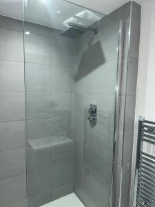 uma casa de banho com uma cabina de duche em vidro e um WC. em Luxury 2 Bedroom Apartment Located In Birmingham City Centre em Birmingham