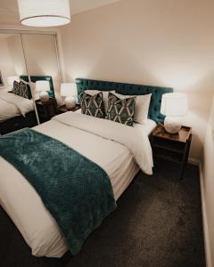 1 dormitorio con 1 cama grande y 2 lámparas en Royal Chambers Serviced Apartments, en Glasgow