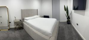 um quarto com uma cama branca e um espelho em Luxury 2 Bedroom Apartment Located In Birmingham City Centre em Birmingham