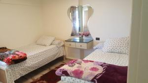 a small room with two beds and a mirror at City Square شقق فندقية مكيفة باطلالة علي البحر in Alexandria