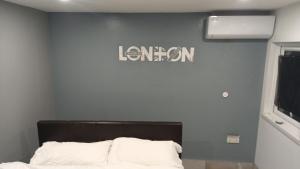 a bedroom with a bed and a sign on the wall at Luxurious En-suite Soft Water Air Conditioning TV RIPPLE in London