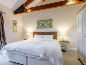 1 dormitorio con 1 cama blanca grande y 2 lámparas en 3 Bed in Sherborne 65854 en Pointington