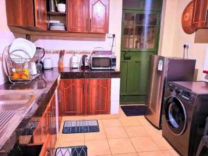 a kitchen with wooden cabinets and a green refrigerator at Gem in Busia