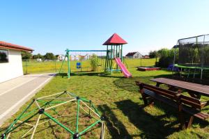 un parque con parque infantil con mesa de picnic y estructura de juegos en Morska Przygoda en Rewal