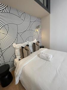 a bedroom with a white bed with a black and white wall at Suite Detroit in Lyon