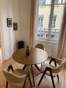 a table and chairs in a room with a window at Suite Detroit in Lyon