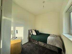 a bedroom with a bed and a dresser and a window at Noormak nights in Birmingham