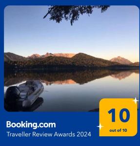 a boat on the water with mountains in the background at Albanta casa con costa en Bariloche in San Carlos de Bariloche