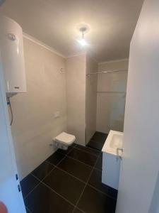 ein Badezimmer mit einem weißen WC und einem Waschbecken in der Unterkunft Apartment for rent in Deçan in Deçan