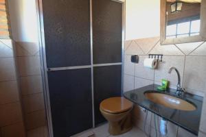 a bathroom with a shower and a toilet and a sink at Pousada Sobradinho in Tiradentes