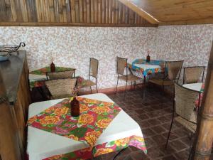 Pousada Sobradinho في تيرادينتيس: غرفة طعام مع طاولتين وكراسي في غرفة