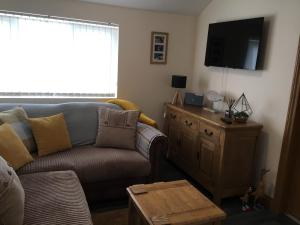sala de estar con sofá y TV de pantalla plana en 88 southshore holiday village, en Bridlington