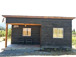 El Durazno的住宿－Cabañas Vista Horizonte，一座小型木结构建筑,里面装有两把椅子