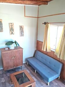 a blue couch and a table in a room at Cabañas Vista Horizonte in El Durazno