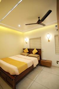 a bedroom with a bed with a ceiling fan at Thekkumbath Sea Breeze Pool villa in Kannur