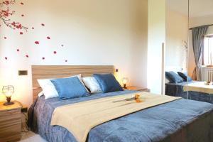 sypialnia z dużym łóżkiem z niebieskimi poduszkami w obiekcie Reggia di Venaria - Tranquillity choice - Parcheggio gratuito - Grand Maison w mieście Venaria Reale
