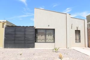 a white house with a black garage door at Casa Malbec in San Martín