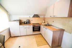 a small kitchen with white cabinets and a sink at Apartment Joga in Rečica ob Savinji