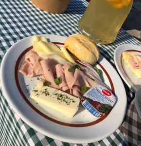 un plato de comida con queso de carne y un sándwich en Villa Bea Panzió, en Zamárdi