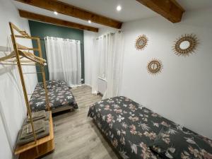 a bedroom with two beds and mirrors on the wall at Maison plain pied au calme in Cuges-les-Pins