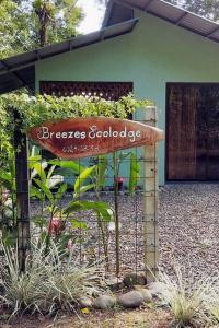 a sign in a garden in front of a house at Breezes Ecolodge in San Ramón