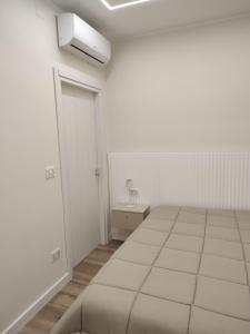 a white room with a bed and a door at Nalí Guest House in Ercolano