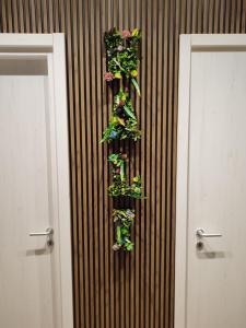Una pared con dos puertas con plantas. en Nalí Guest House, en Ercolano