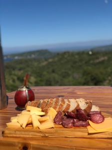 a cutting board with meat cheese and bread and an apple at Modulo - Gorska Voda in Embalse