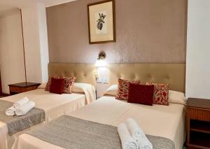 una camera d'albergo con due letti e asciugamani di Hotel Atlántico Centro a Santa Cruz de Tenerife