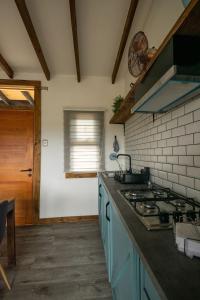 a kitchen with blue cabinets and a stove top oven at Cabañas Lawal Puerto Varas/con Tinaja in Puerto Varas