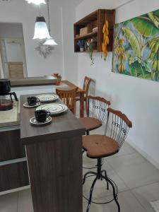 a kitchen with a island with chairs and a table at Não é studio, apto espaçoso 70m, 2 quartos, sacada fechada, garagem e bem no centro in Florianópolis