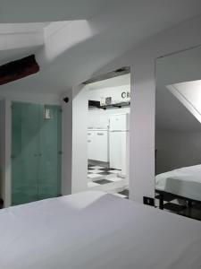 a white room with a bed and a kitchen at bijou loft in La Spezia