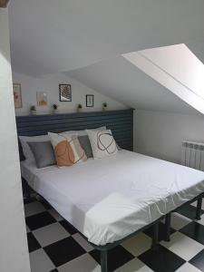 a bed with white sheets and pillows in a room at bijou loft in La Spezia