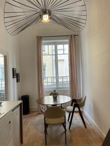 a dining room with a table and chairs and a window at Suite Carter in Lyon