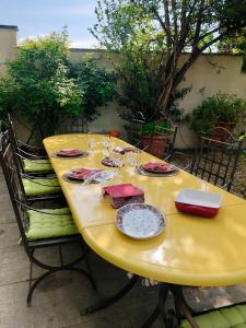 a yellow table with plates and dishes on it at 140 du Ventoux in Saint-Saturnin-lès-Avignon