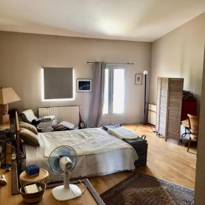 a bedroom with a large bed with a fan at 140 du Ventoux in Saint-Saturnin-lès-Avignon