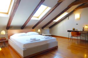 a bedroom with a large white bed with skylights at Politecnico di Torino - Design Suite Hydrangea - Grand Maison in Turin