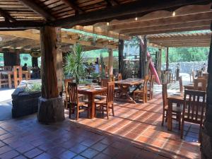a restaurant with wooden tables and chairs on a patio at Cabañas Route G25 in Melocotón