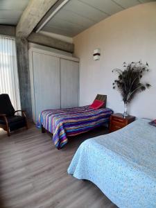 una habitación de hotel con 2 camas y una silla en Itaca Hostel finca Cafetera, en Belalcázar